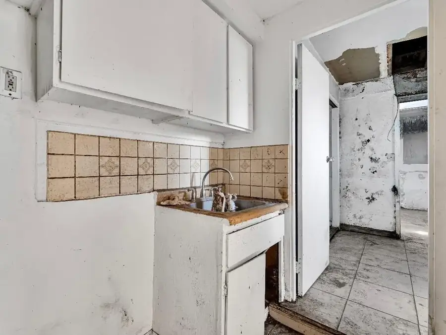 Damaged kitchen with mold and water damage before renovation
